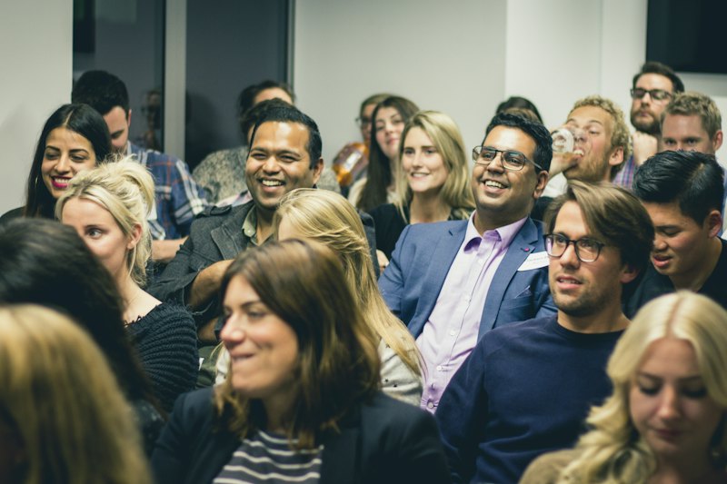 Business owners smiling in the audience at a chamber meeting