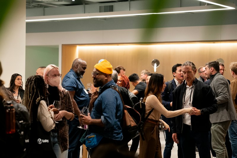 People talking and shaking hands at a networking mixer